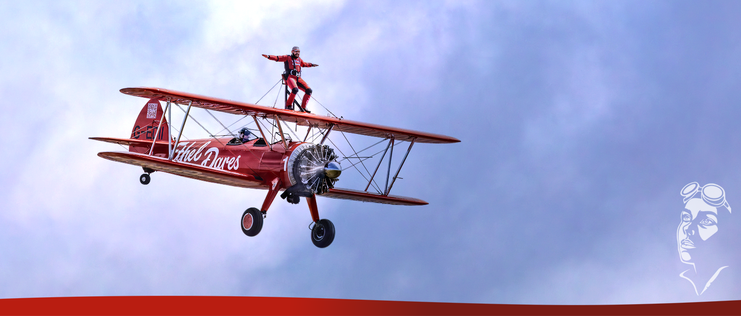 Ethel Dares G-EDII biplane with wingwalker in flight